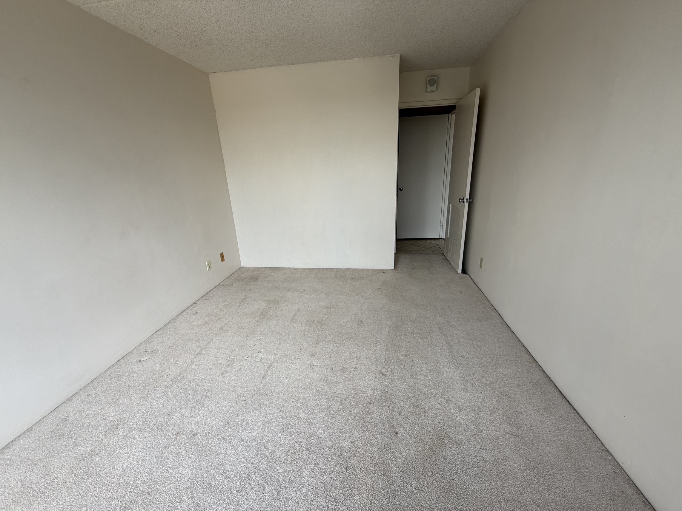 A room with a carpeted floor and white walls.
